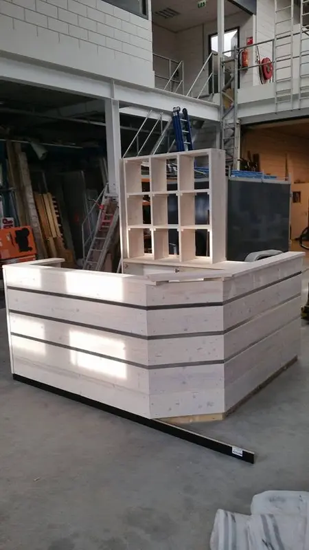 Balie in aanbouw in een werkruimte, met planken, stangen en gereedschap