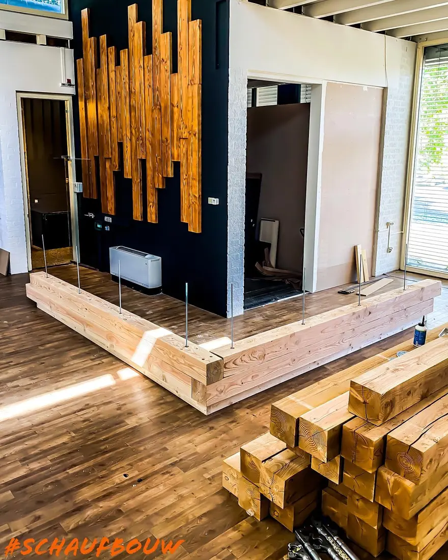 Hoekvormige balie van dikke planken in aanbouw